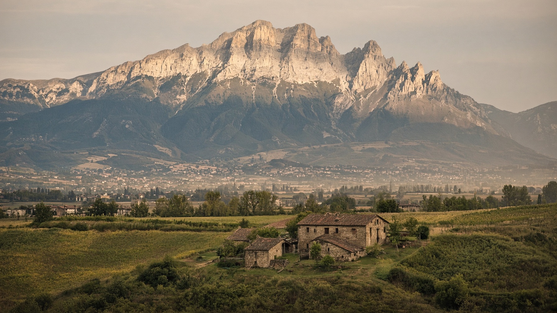 Fields and farmsteads at the edge of the Italian mountains